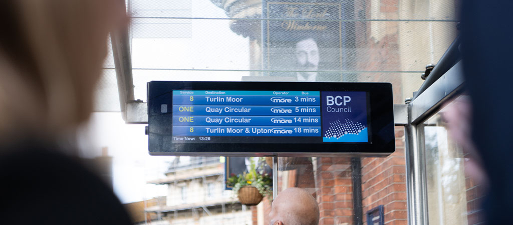 The images shows a Journeo passenger information display showing bus departures in a shelter.